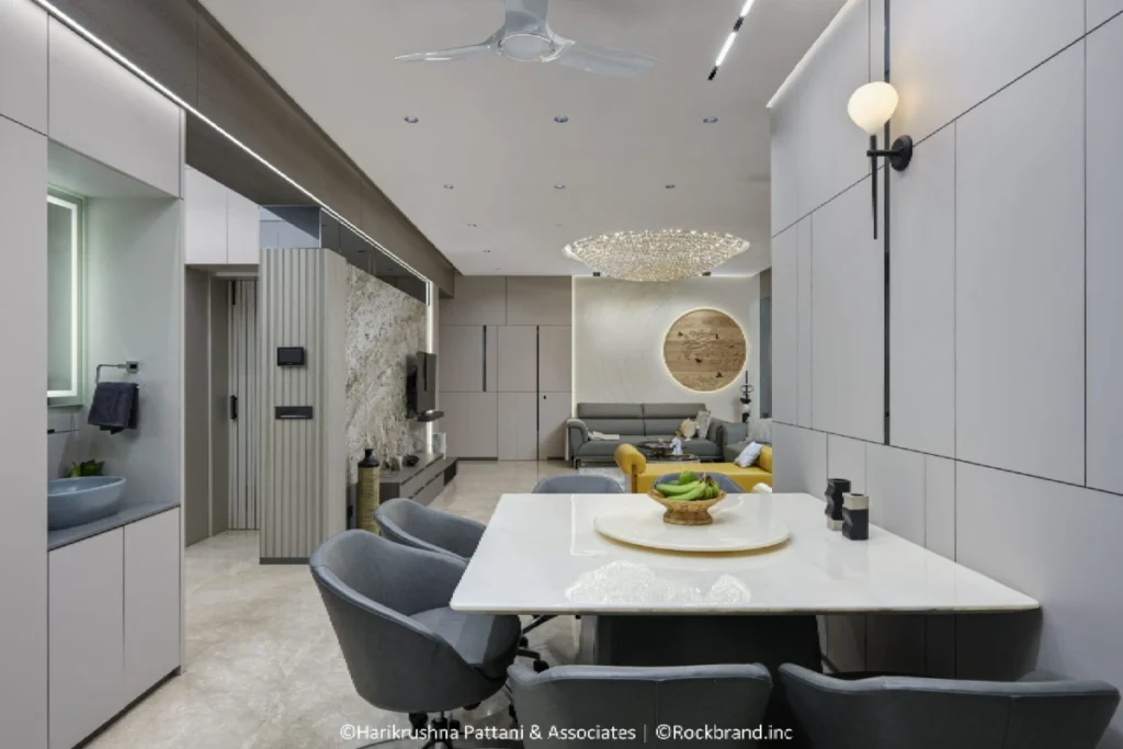 Dining table with grey chairs in luxury apartment interior at Sharanya Skyvue Ahmedabad